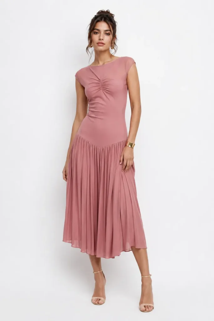 Woman wearing sage green drop-waist chiffon midi dress at outdoor wedding venue